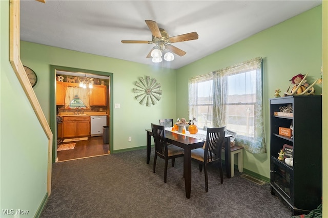 carpeted dining room with ceiling fan