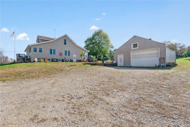 exterior space with a garage and an outbuilding