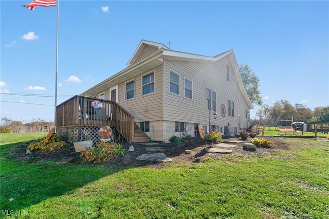 view of side of property with a yard and a wooden deck