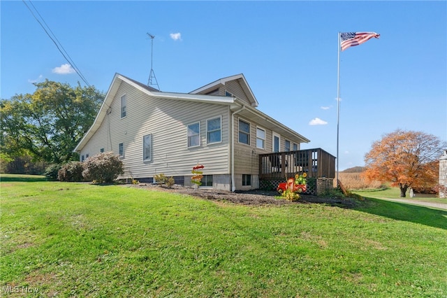 view of side of home with a deck and a lawn