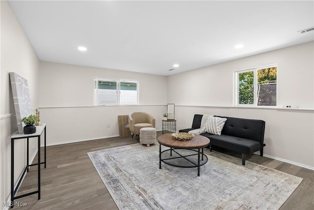 living area with recessed lighting, visible vents, baseboards, and wood finished floors