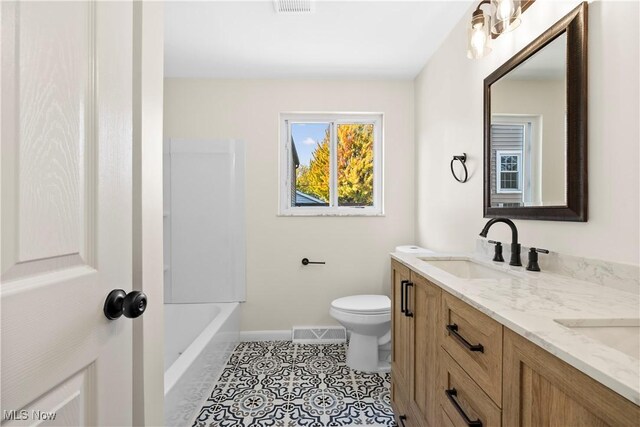 full bathroom with visible vents, double vanity, a sink, tile patterned floors, and toilet