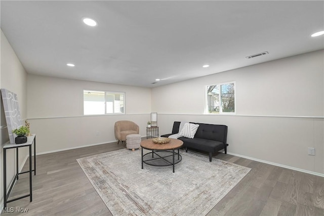 sitting room with visible vents, plenty of natural light, and wood finished floors