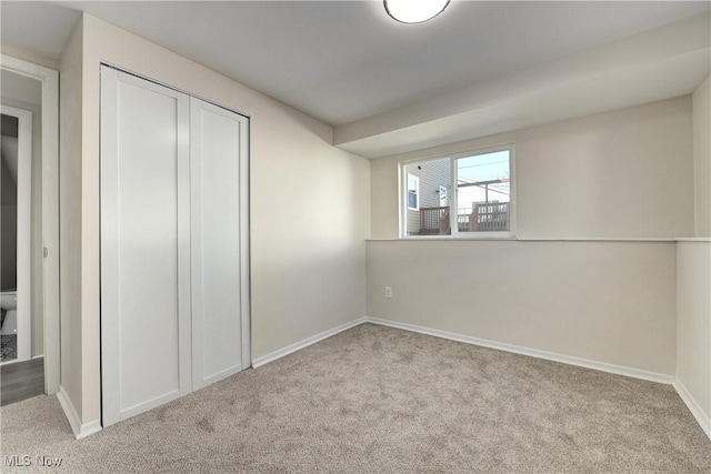 unfurnished bedroom with a closet, baseboards, and carpet