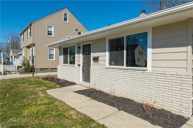 exterior space featuring brick siding and a lawn