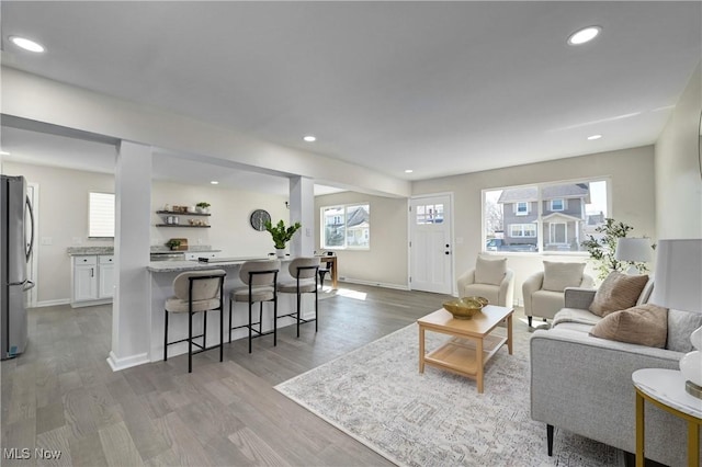 living area featuring recessed lighting, light wood-type flooring, and baseboards