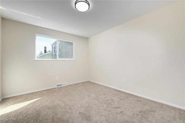 carpeted empty room with visible vents and baseboards