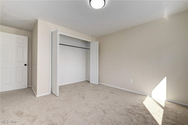 unfurnished bedroom featuring baseboards, a closet, and carpet floors