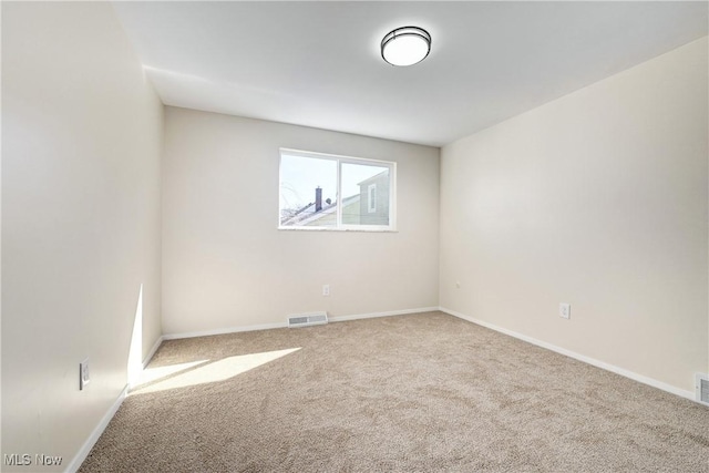 empty room with visible vents, baseboards, and carpet flooring