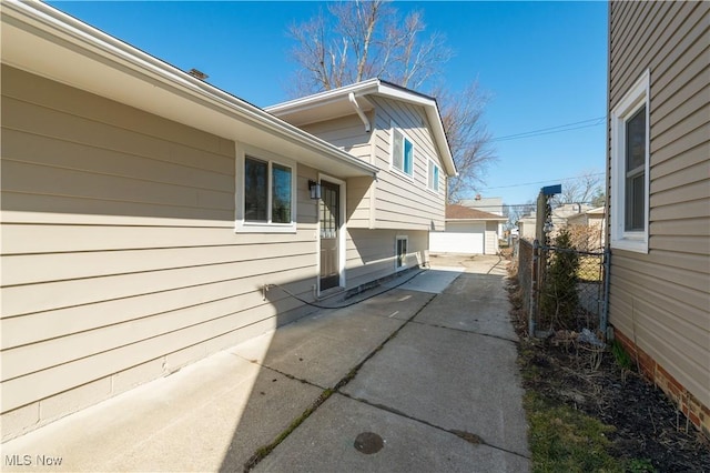 view of patio featuring a garage, an outdoor structure, and fence