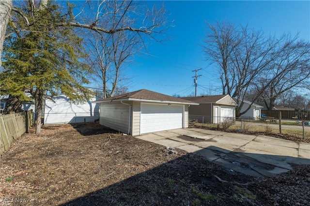 view of side of home featuring a garage, an outdoor structure, and fence