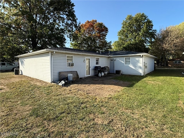 rear view of house with central air condition unit, a lawn, and cooling unit