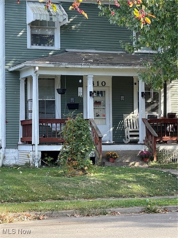 property entrance featuring a yard and a porch