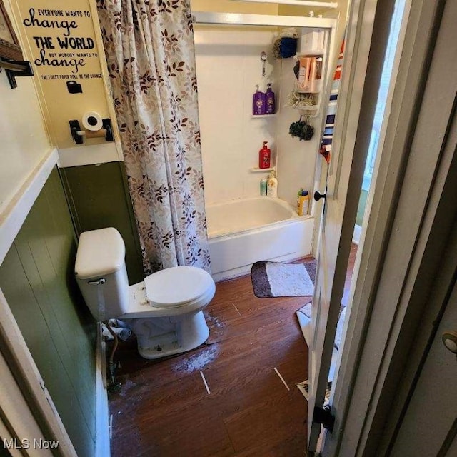 bathroom featuring toilet, wood-type flooring, and shower / tub combo