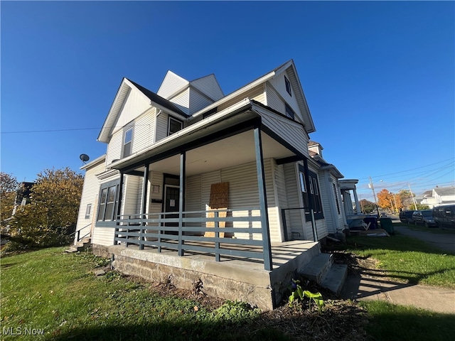 view of home's exterior featuring covered porch and a lawn