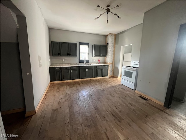 kitchen with wood-type flooring, sink, white range with electric stovetop, and gray cabinets