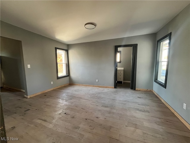 unfurnished bedroom featuring vaulted ceiling and light hardwood / wood-style floors