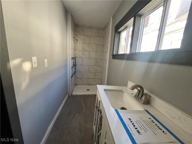 bathroom featuring vanity, hardwood / wood-style floors, and tiled shower