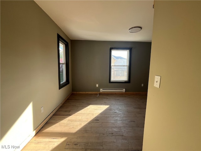 unfurnished room with light hardwood / wood-style flooring and baseboard heating