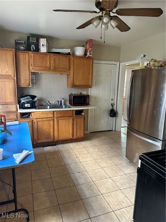 kitchen featuring stainless steel fridge, ceiling fan, backsplash, sink, and electric range oven