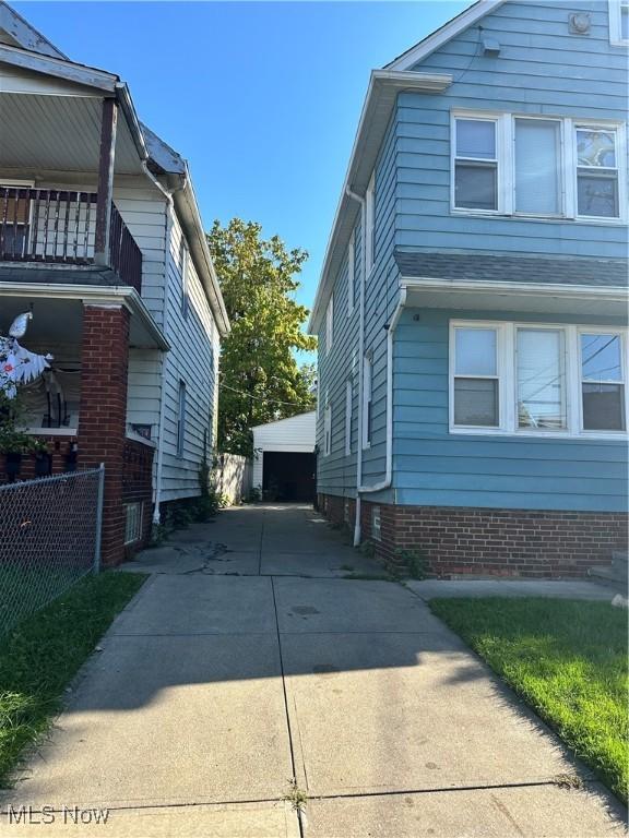 16512 Burnside Ave, Cleveland, OH 44110 - view of property exterior featuring a garage, an outbuilding, fence, and a balcony
