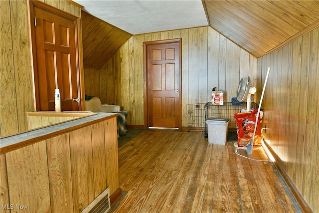 additional living space featuring wood ceiling, wood-type flooring, vaulted ceiling, and wooden walls