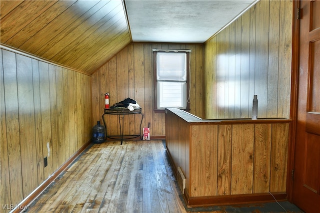 bonus room with wood walls, vaulted ceiling, and hardwood / wood-style floors