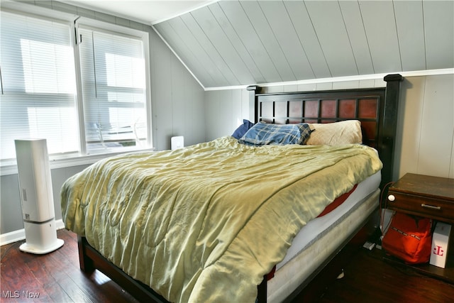 bedroom with vaulted ceiling and dark hardwood / wood-style floors