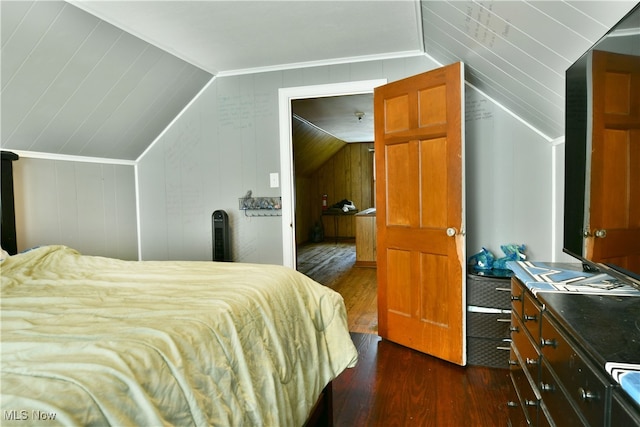 bedroom with dark wood-type flooring, lofted ceiling, and wooden walls