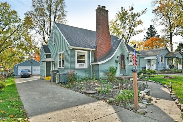 bungalow-style home featuring a garage and an outbuilding