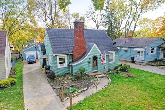 view of front of property featuring a front yard, an outbuilding, and a garage