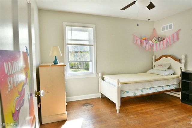 bedroom featuring multiple windows, hardwood / wood-style floors, and ceiling fan