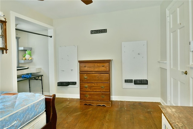 bedroom featuring dark wood-type flooring, a closet, and ceiling fan