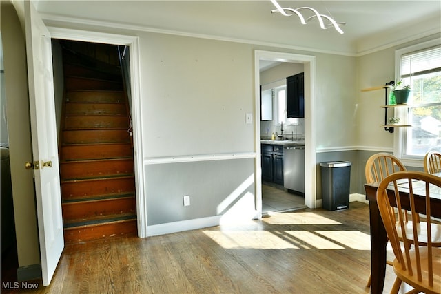 dining space with crown molding and light hardwood / wood-style flooring