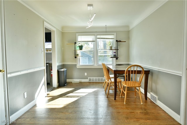 dining room with crown molding and wood-type flooring