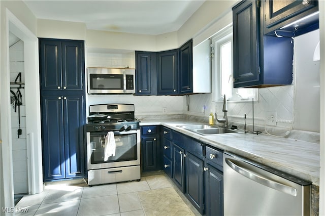 kitchen with light tile patterned floors, stainless steel appliances, tasteful backsplash, and sink