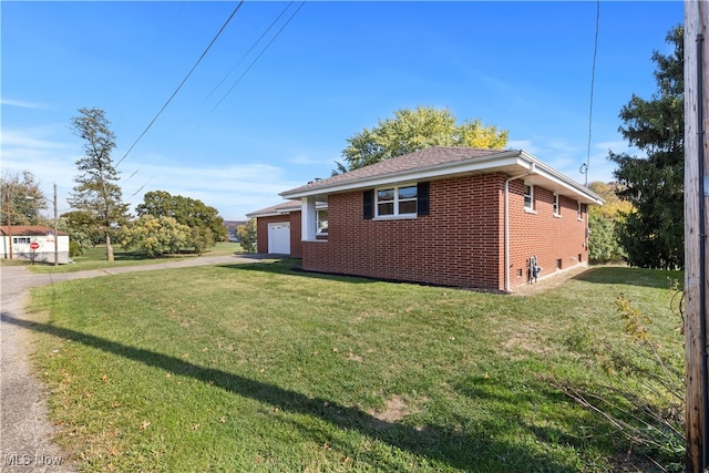 view of side of property with a yard and a garage