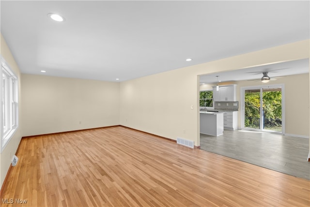 unfurnished living room with light hardwood / wood-style floors and ceiling fan