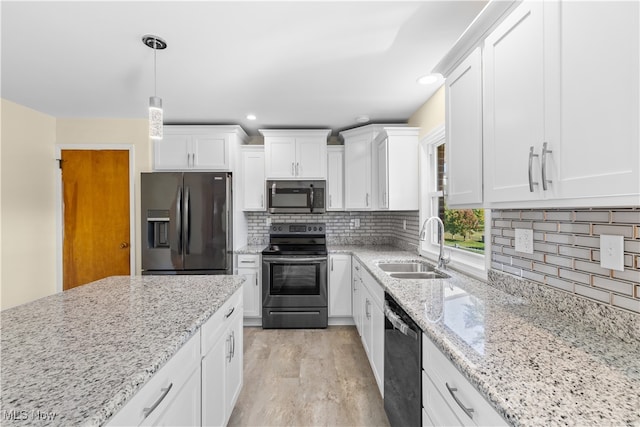 kitchen featuring white cabinets, hanging light fixtures, appliances with stainless steel finishes, light wood-type flooring, and sink