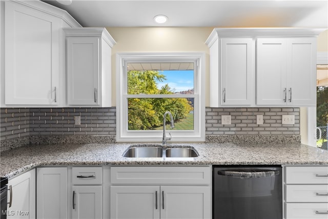 kitchen with backsplash, sink, stainless steel dishwasher, and white cabinets