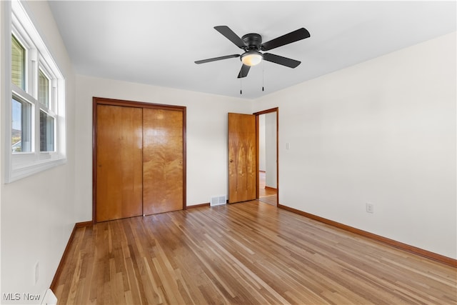 unfurnished bedroom with a closet, ceiling fan, and light wood-type flooring