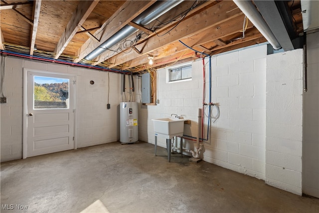 basement featuring electric water heater, electric panel, and plenty of natural light