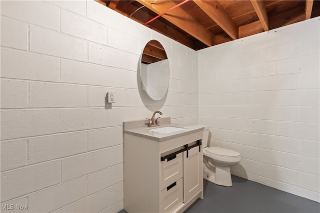 bathroom featuring vanity, concrete flooring, and toilet