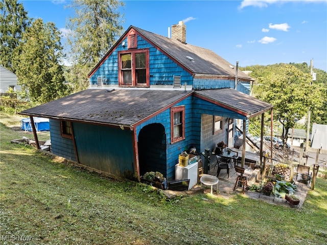 rear view of property featuring a lawn