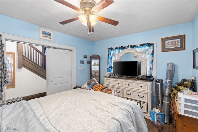 bedroom featuring a closet, dark hardwood / wood-style floors, and ceiling fan