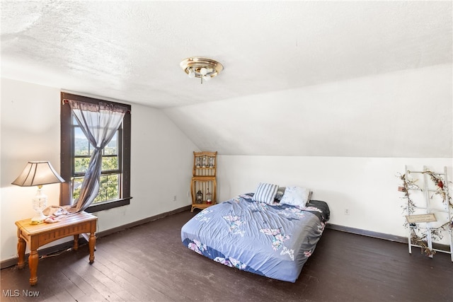 bedroom featuring dark hardwood / wood-style floors, a textured ceiling, and vaulted ceiling