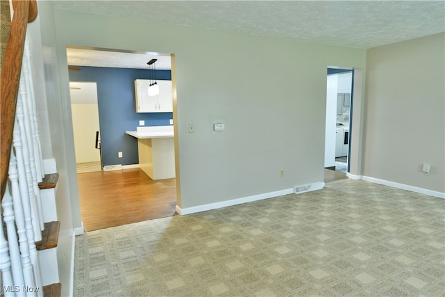 empty room with a textured ceiling and light wood-type flooring