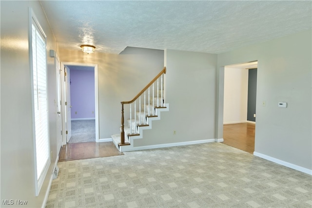 unfurnished room featuring a textured ceiling and light hardwood / wood-style flooring