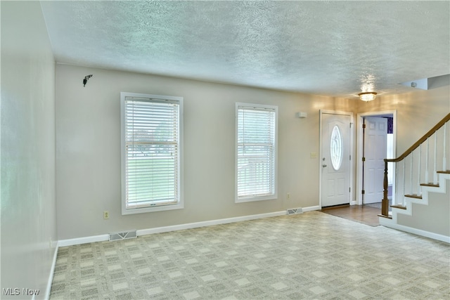 foyer entrance featuring a textured ceiling