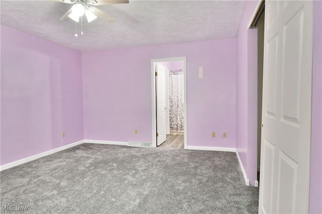 unfurnished bedroom featuring carpet, a textured ceiling, ensuite bath, and ceiling fan